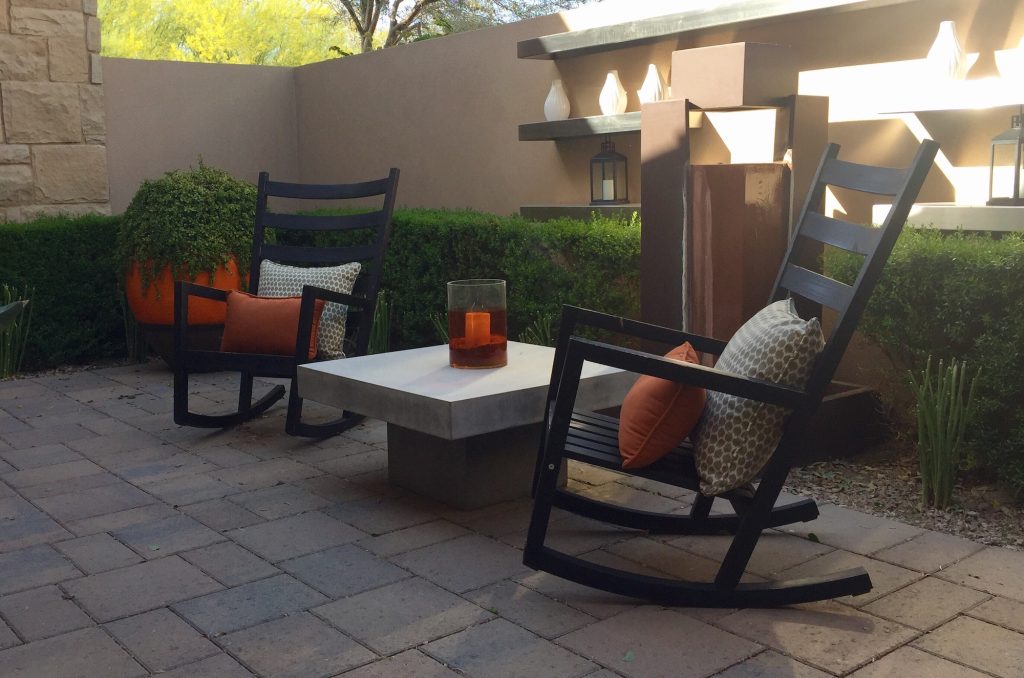 Eclectic furnishings on a patio with rocking chairs and modern table